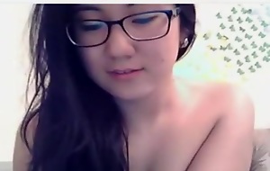 Nerdy brunette Asian webcam girl undresses and flirts for the vie